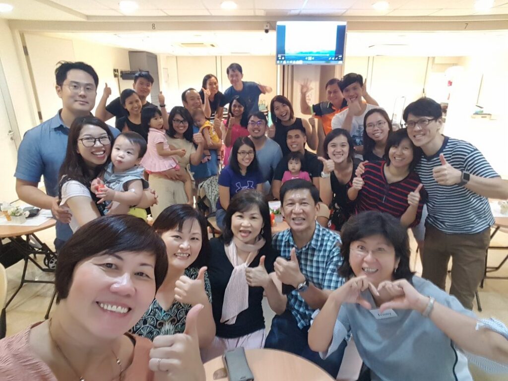 Couples and families at a Careworks marriage event, smiling and giving thumbs up